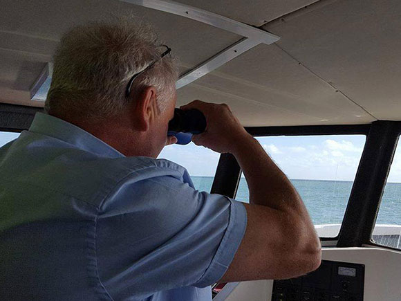 The captain looking out through binoculars